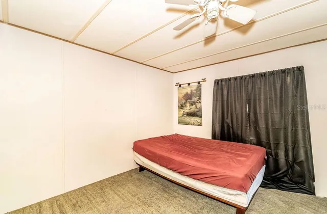 a bed sitting in a bedroom next to a window