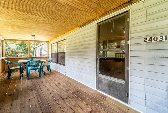 a view of a porch with furniture and wooden floor