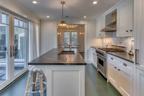 a kitchen with stainless steel appliances granite countertop a stove a sink and a refrigerator