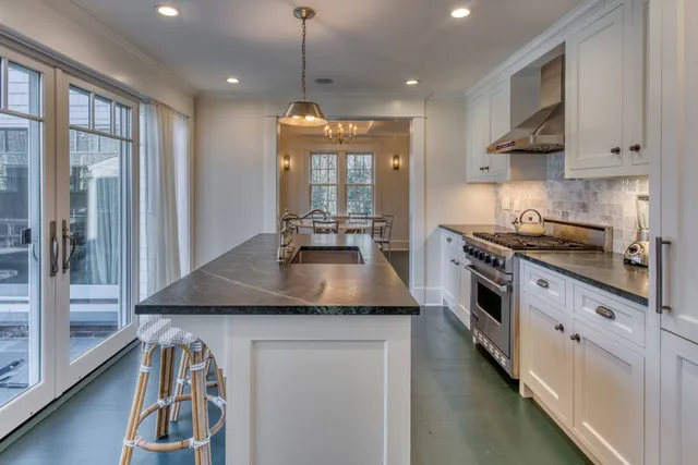 a kitchen with stainless steel appliances granite countertop a stove a sink and a refrigerator