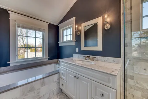 a bathroom with a granite countertop sink toilet and mirror