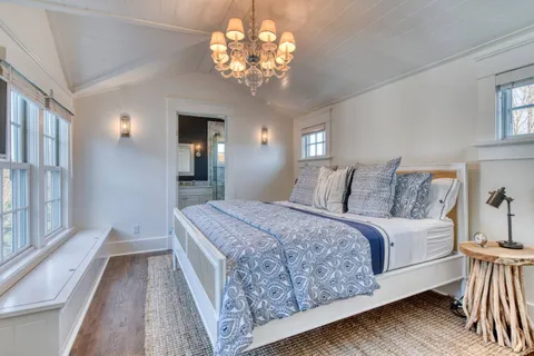 a spacious bedroom with a large bed and a chandelier
