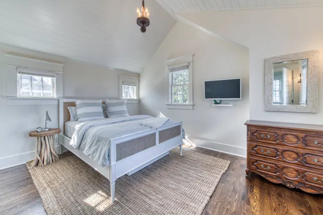 a bedroom with a bed and a flat tv screen on dresser