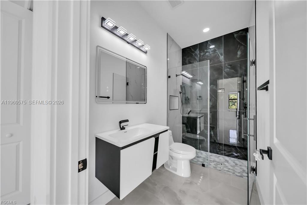 711 Roma Avenue Lehigh Acres, FL 33974 - Photo 15 of 38 a bathroom with a toilet sink and mirror