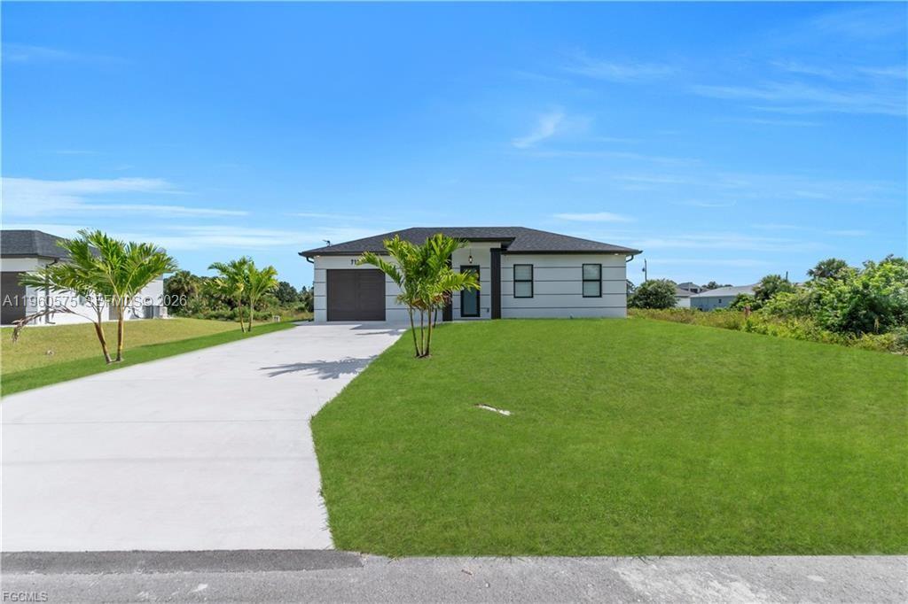 711 Roma Avenue Lehigh Acres, FL 33974 - Photo 4 of 38 a view of a house with a yard and potted plants