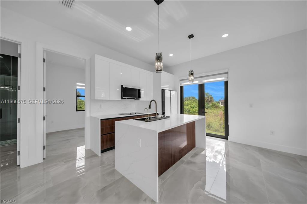 711 Roma Avenue Lehigh Acres, FL 33974 - Photo 6 of 38 a view of kitchen with stove and refrigerator