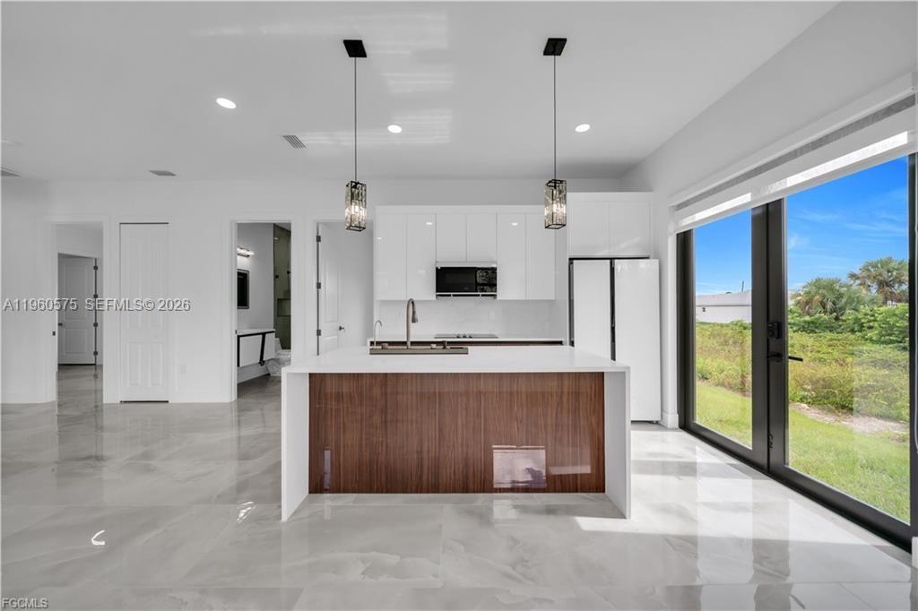 711 Roma Avenue Lehigh Acres, FL 33974 - Photo 7 of 38 a view of a kitchen with a sink and a fireplace