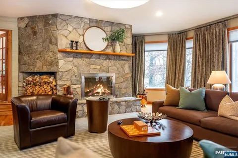 a living room with furniture a fireplace and a large window