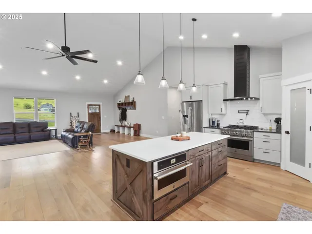 a large kitchen with kitchen island a sink stainless steel appliances and cabinets