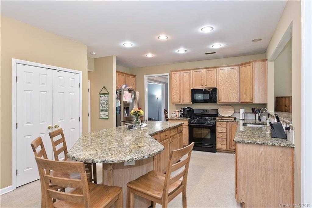 255 Choate Avenue Fort Mill, SC 29708 - Photo 10 of 38 a kitchen with kitchen island granite countertop wooden cabinets and stainless steel appliances