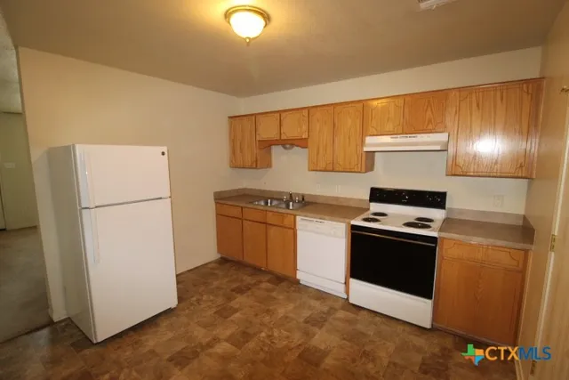 a kitchen with a refrigerator sink stove and cabinets