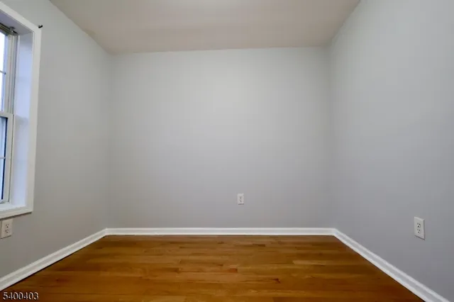 a view of a room with wooden floor and white walls