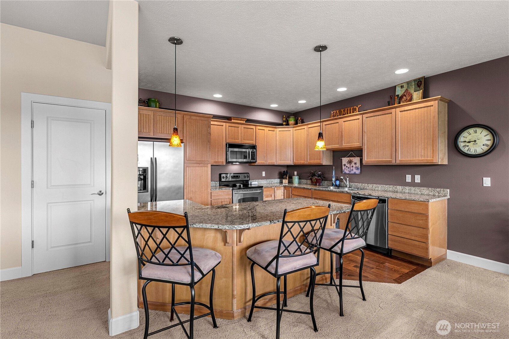 9122 Red Hawk Lane Northwest, Unit A76 Quincy, WA 98848 - Photo 12 of 40 a kitchen with stainless steel appliances granite countertop a kitchen island a table and chairs in it