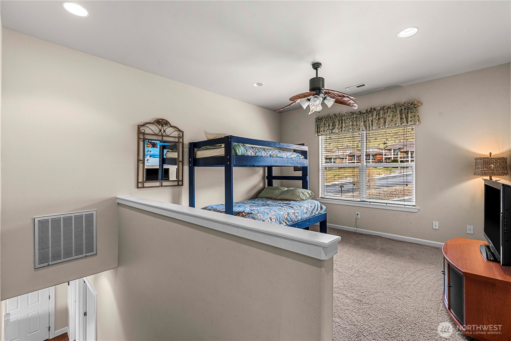 9122 Red Hawk Lane Northwest, Unit A76 Quincy, WA 98848 - Photo 25 of 40 a living room with furniture a chandelier a flat screen tv and a window