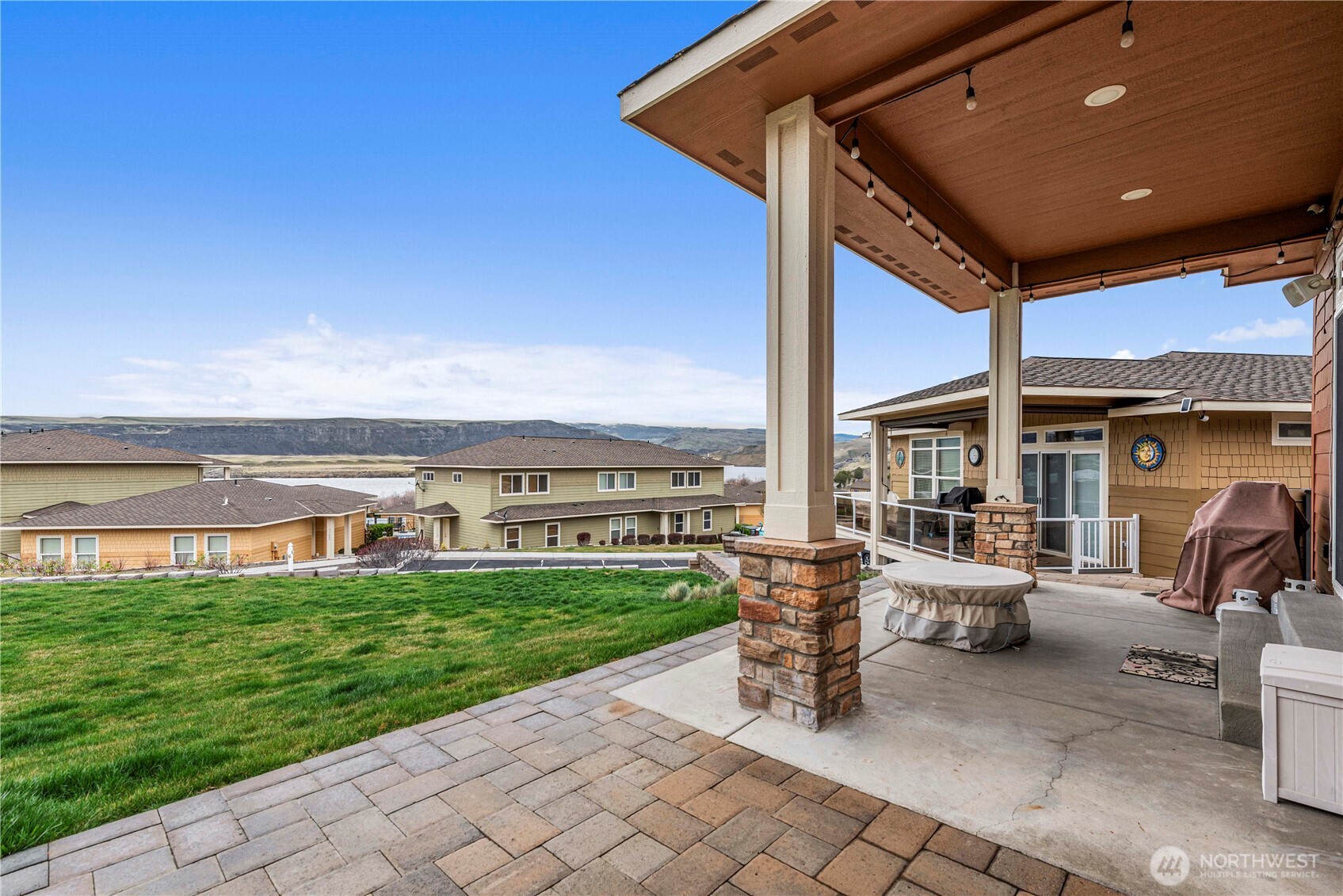 9122 Red Hawk Lane Northwest, Unit A76 Quincy, WA 98848 - Photo 31 of 40 a view of a patio with dining table and chairs with a yard