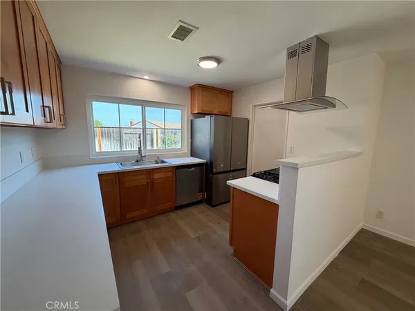 a kitchen with sink a refrigerator and window