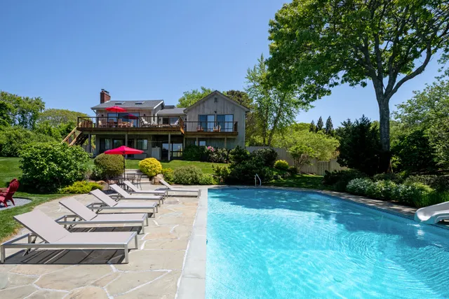 a view of a patio with table and chairs potted plants and large tree