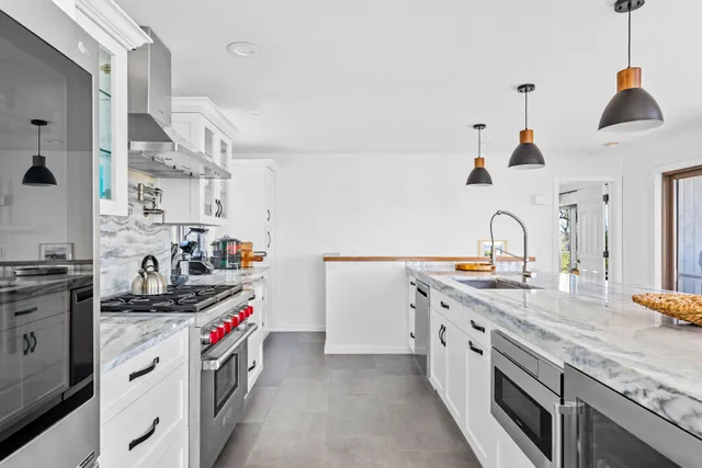 a kitchen with granite countertop a sink a stove and cabinets