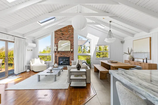 a living room with fireplace furniture and a large window