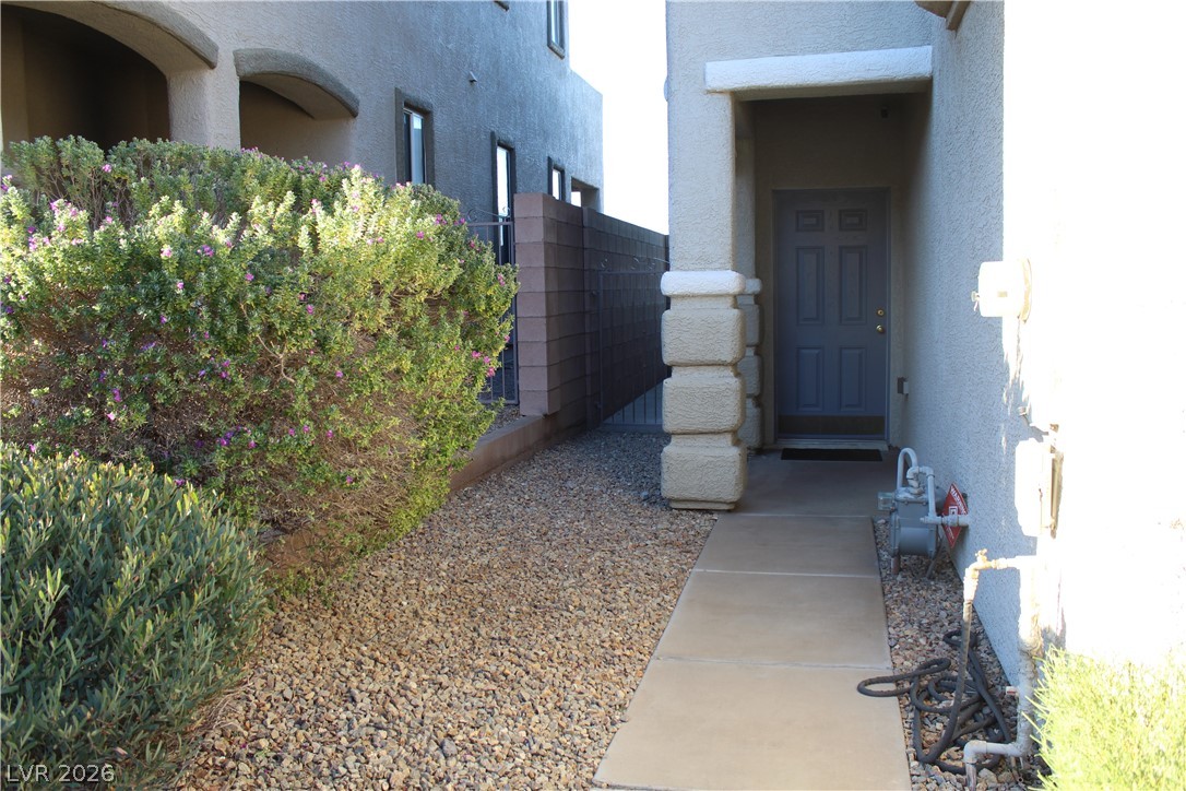 207 Priority Point Street Henderson, NV 89012 - Photo 2 of 23 A concrete walkway guides visitors past manicured desert landscaping to a sheltered entry door.