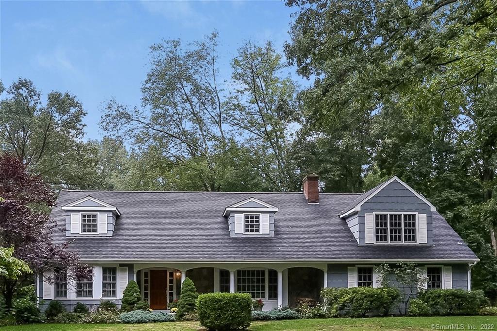 a front view of a house with a yard and trees