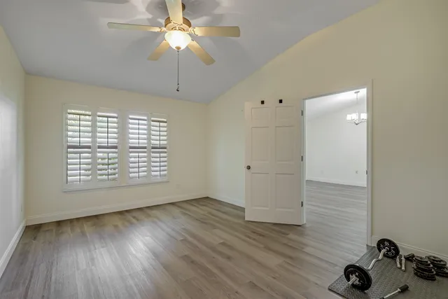 an empty room with a window and a ceiling fan