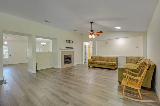 a kitchen with stainless steel appliances granite countertop a refrigerator a sink dishwasher a stove and white countertops with wooden floor