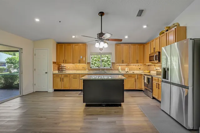 a kitchen with stainless steel appliances granite countertop a sink a stove and refrigerator