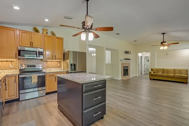 a kitchen with stainless steel appliances granite countertop a sink and cabinets