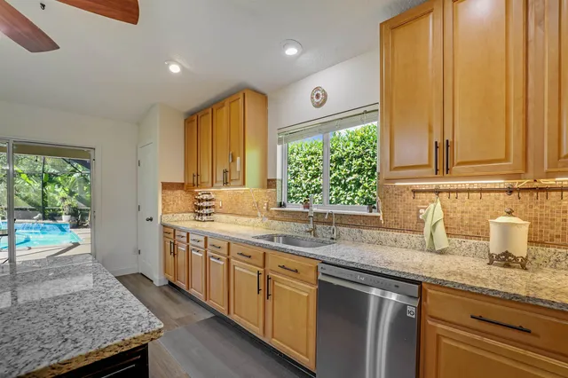 a kitchen with stainless steel appliances granite countertop a stove cabinets and wooden floor