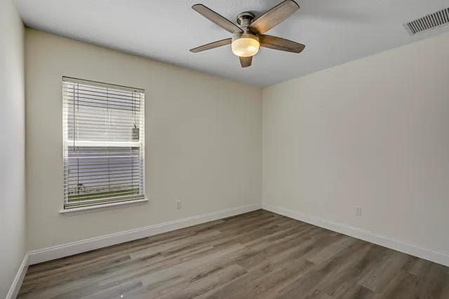 a view of empty room with wooden floor