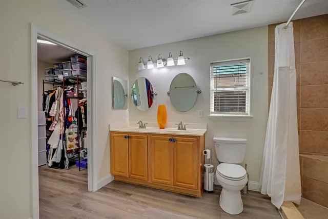 a bathroom with a double vanity sink toilet and shower