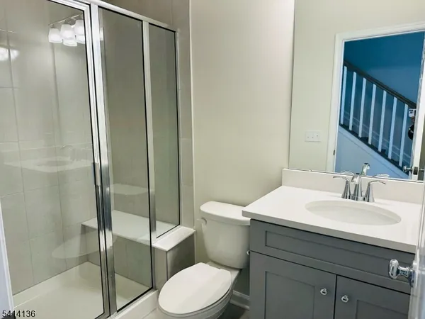 a bathroom with a sink toilet vanity and shower