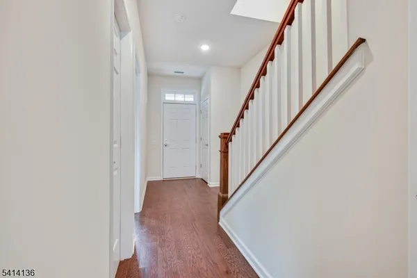 a view of a hallway with wooden floor and staircase