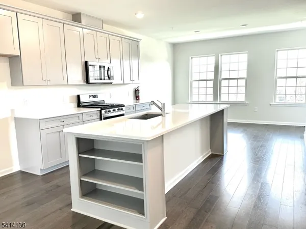 a kitchen with a sink cabinets appliances and a window