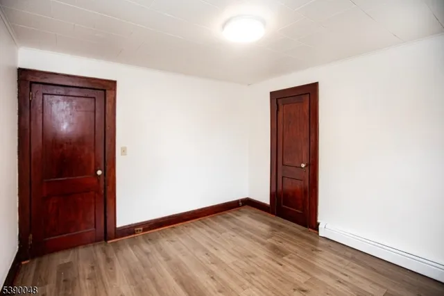 an empty room with wooden floor and closet