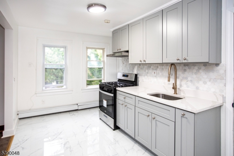 20 Summit Avenue, Unit 2 Hawthorne, NJ 07506 - Photo 9 of 24 a kitchen with a sink window and cabinets