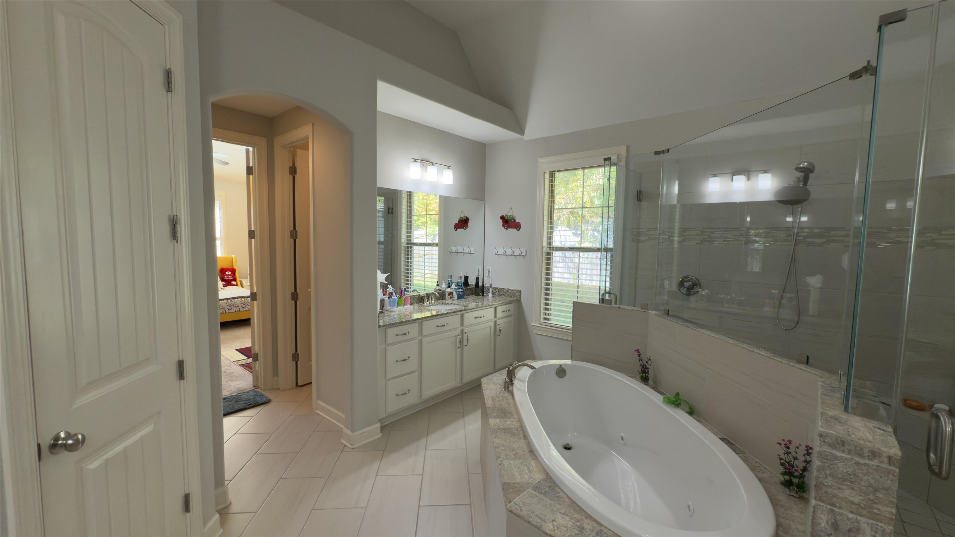 1217 Pilgrim Ridge Road Collierville, TN 38017 - Photo 20 of 33 Bathroom featuring a tub with jets, vanity, a stall shower, and vaulted ceiling