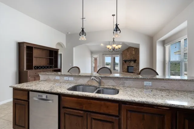 a kitchen with kitchen island granite countertop a sink and chandelier
