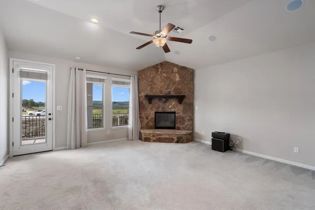 a view of an empty room with a fireplace and a window