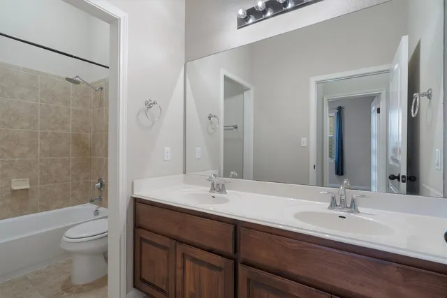 a bathroom with a double vanity sink toilet and shower