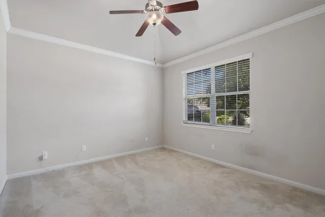 an empty room with a window and a ceiling fan