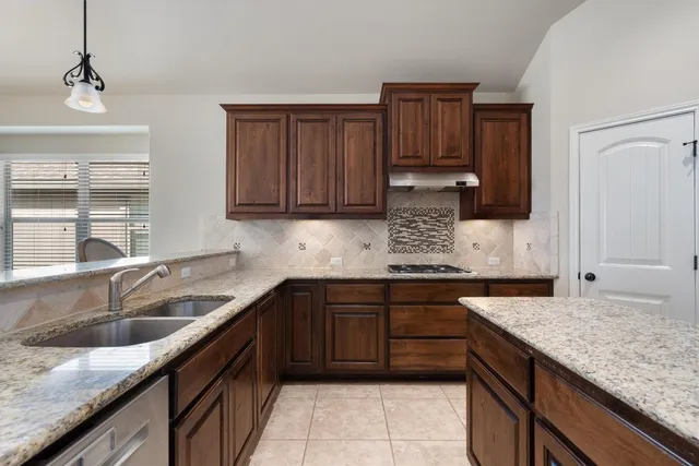 a kitchen with granite countertop stainless steel appliances granite countertop wooden cabinets a sink and dishwasher