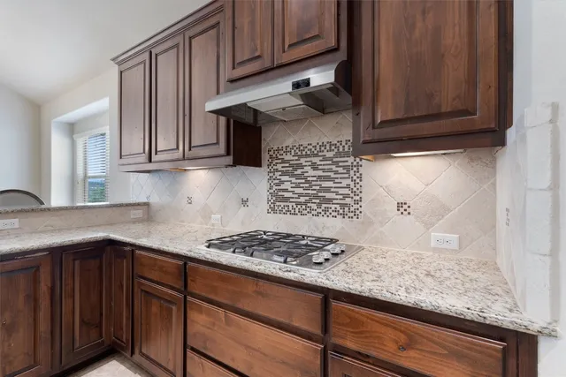 a kitchen with granite countertop stainless steel appliances stove and cabinets