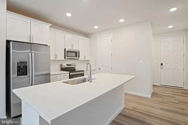 a kitchen with sink a microwave and refrigerator