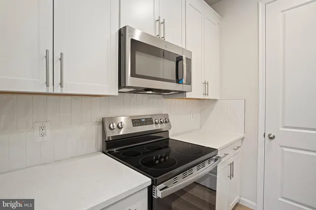 a kitchen with microwave cabinets and stove top oven