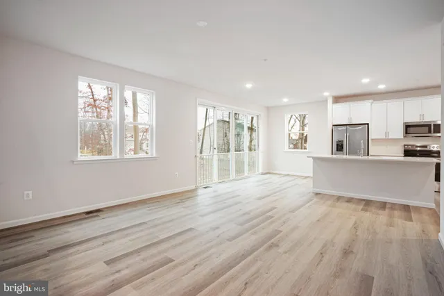 a view of a kitchen with wooden floor and a window