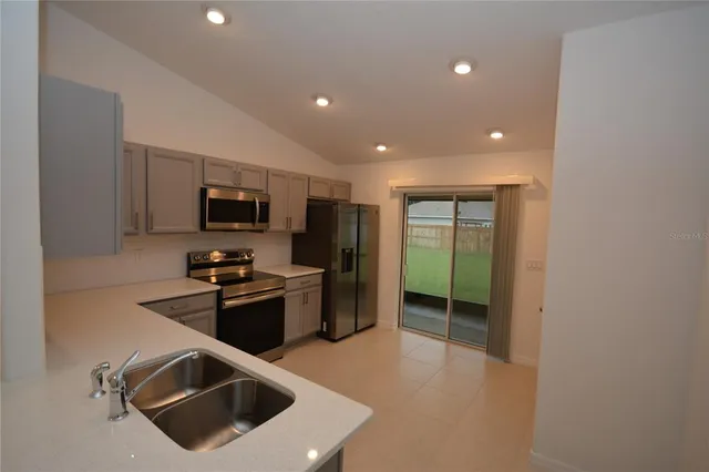 a kitchen with stainless steel appliances a refrigerator and a stove top oven