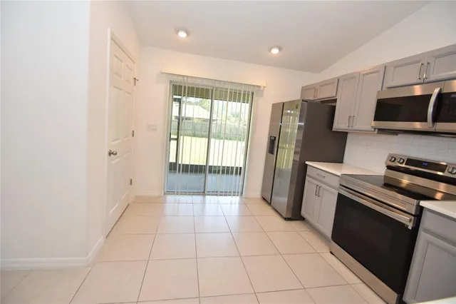 a kitchen with stainless steel appliances a refrigerator and a stove top oven