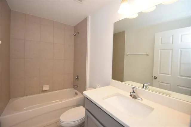 a bathroom with a bathtub shower sink vanity mirror and toilet